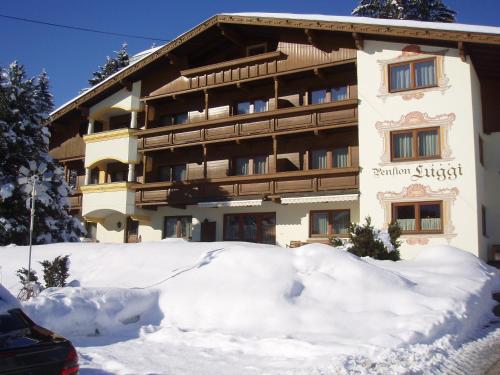 ein Gebäude mit einem Stapel Schnee davor in der Unterkunft das Luggi Appartements in Reith im Alpbachtal