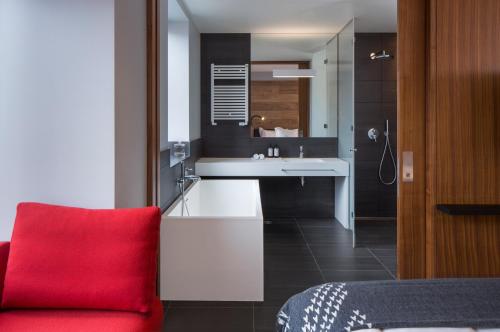 a bathroom with a red chair next to a sink at ION City Hotel, Reykjavik, a Member of Design Hotels in Reykjavík