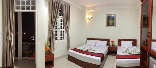 a bedroom with two beds and a window at Truong Ca Hotel in Phan Thiet