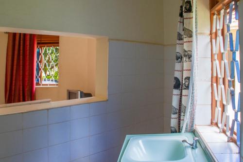 a bathroom with a sink and a mirror at Wal Ville Suites in Gulu