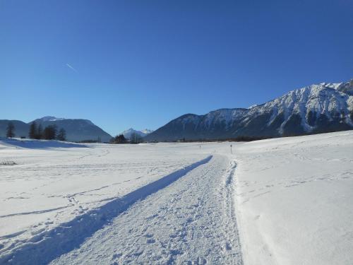 a snow covered field with mountains in the background at Pension Sonnenhof in Mieming