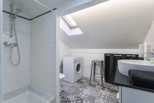 a bathroom with a shower sink and a washing machine at cocon des artistes in Lyon