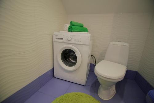 a bathroom with a washing machine and a toilet at Апартаменти Маяк in Odesa