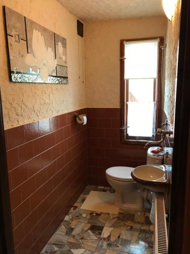 baño con aseo y lavabo y ventana en Apartament Widok, en Czarna Góra