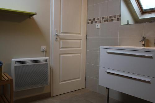 a bathroom with a white door and a sink at L'Etape in Belley