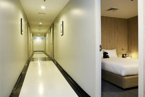 a hallway leading to a bedroom with a bed at Sleep Box by Miracle -Booked on Hourly Basis in Bangkok
