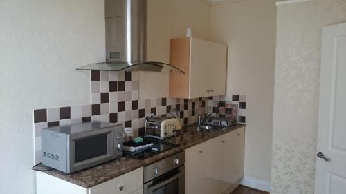 a kitchen with a microwave and a tv on a counter at Strathmore Apartments in Lytham St Annes