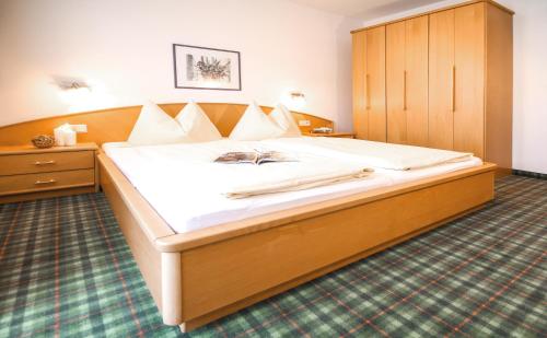 a bedroom with a large bed with a wooden cabinet at Holzmannhof in Flachau