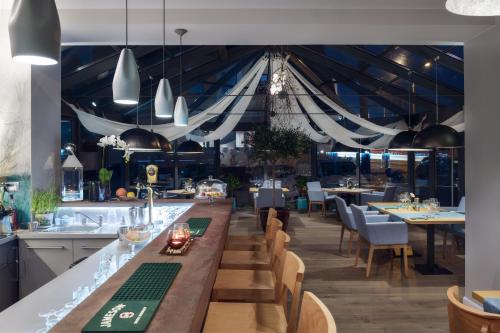ルミアにあるVilla Zagórzeの長いバー(椅子、テーブル付)のあるレストランを提供しています。