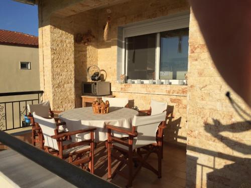 a patio with a table and chairs on a balcony at POSSIDI - Ithaki Holiday Apartments in Kalandra