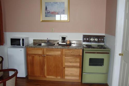 a kitchen with a sink and a stove at Royal Napanee Inn in Napanee