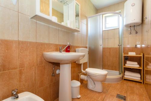 ein Bad mit einem Waschbecken, einem WC und einer Dusche in der Unterkunft Apartment Oreskovic in Krk
