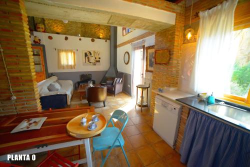 a kitchen and a living room with a table and a kitchen at Casa Rural La Rocha in Chulilla
