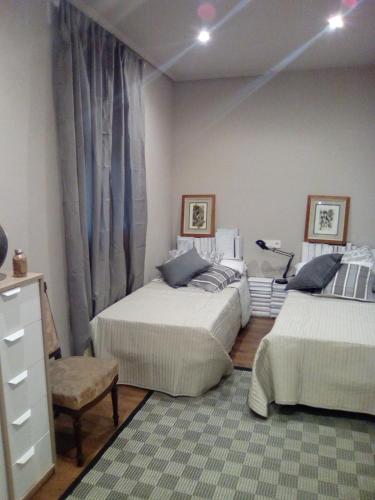 a bedroom with two beds and a dresser at Jan&Joan Apartment in Bilbao