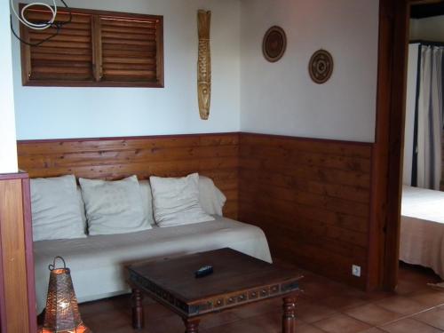 a room with a white couch and a table at Le Cardinal des Grands Bleus in Saint-Leu