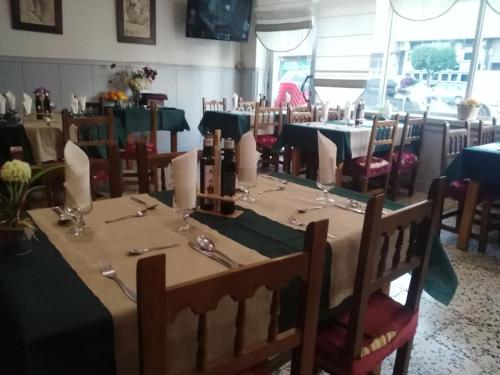 una sala da pranzo con tavolo, sedie e tavolo con balaustra di Hotel Delphos a Moraleja