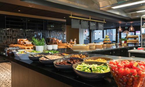 a buffet with many bowls of food on a counter at Thon Hotel Oslo Airport in Gardermoen