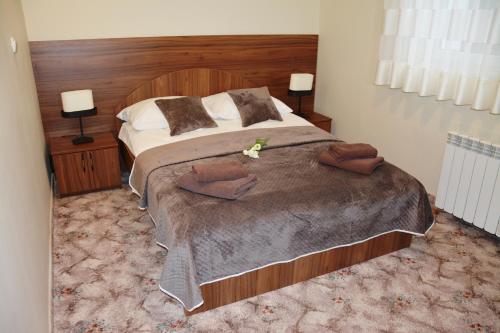 a bedroom with a large bed with a wooden headboard at Hotel Irena in Morąg