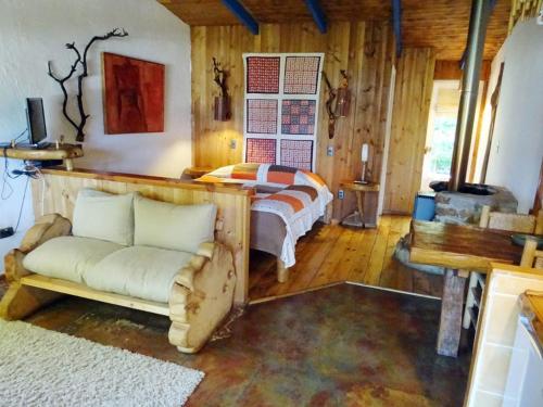 a bedroom with a bed and a couch in a room at Cabañas Hermansen in Maitencillo
