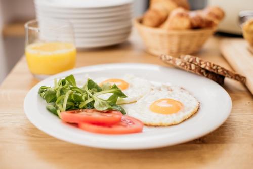 a plate of food with eggs and greens on a table at Sundial Boutique Hotel in Zagreb