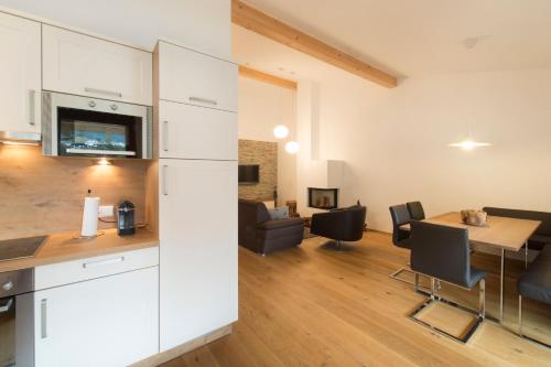 a kitchen and living room with a table and chairs at Verwall Apartment in Schruns-Tschagguns