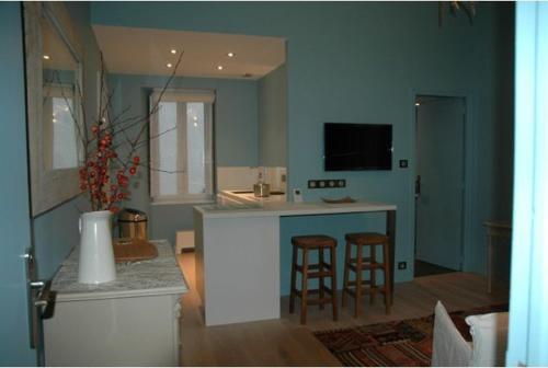 a living room with a kitchen with a counter and stools at Quimper-Appart in Quimper