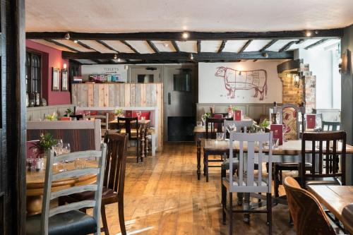 a dining room with tables and chairs in a restaurant at The White Lion in Tenterden