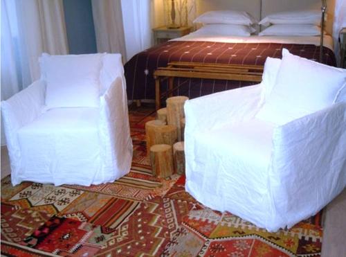 - une chambre avec un lit doté de draps blancs et d'une chaise dans l'établissement Quimper-Appart, à Quimper