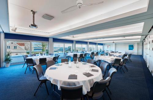 a conference room with tables and chairs and large windows at Hotel Marina in Vedbæk