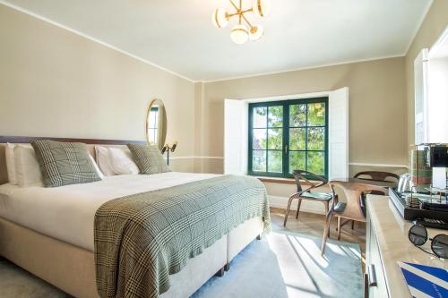 a bedroom with a bed and a desk and a window at Hotel Brown Beach House & Spa in Trogir