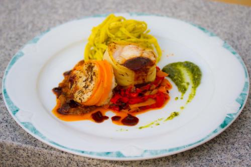 a plate of food with meat and vegetables on a table at Hotel Birkenhof in Hanau am Main