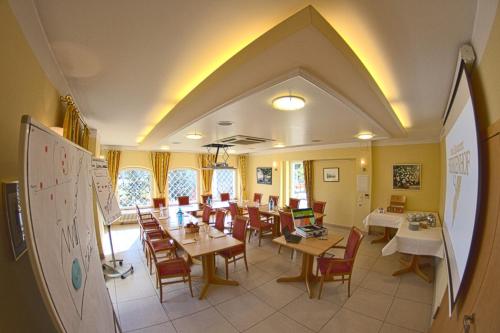 a classroom with a dining room with tables and chairs at Hotel Birkenhof in Hanau am Main