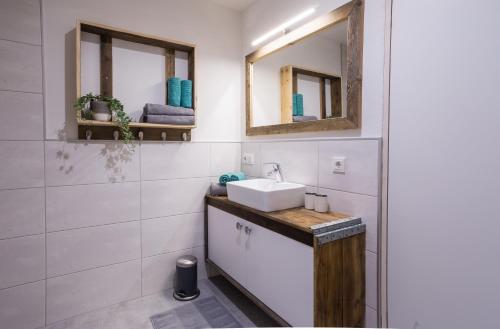 uma casa de banho com um lavatório e 2 espelhos em Hochsitz Schladming em Schladming