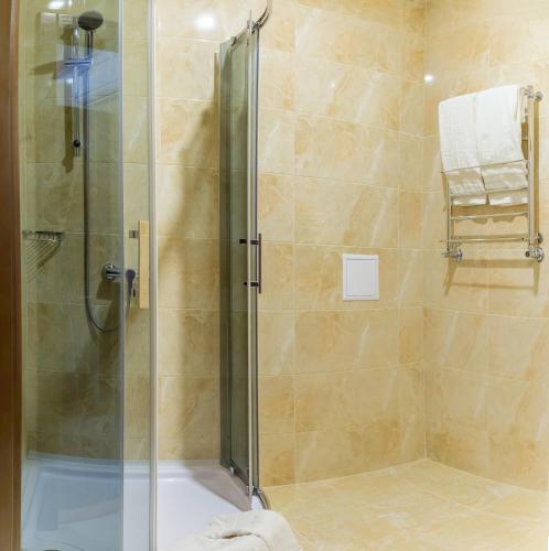 a bathroom with a shower with a glass door at Hotel Patriarshyi in Lviv