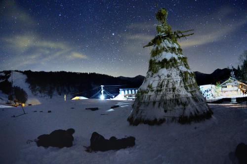 a christmas tree in the snow at night at Spa Lodge Redwood Inn in Takayama