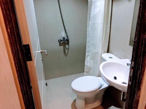 a bathroom with a toilet and a shower and a sink at TechieRoom Swift at Clove Garden Residence in Bandung