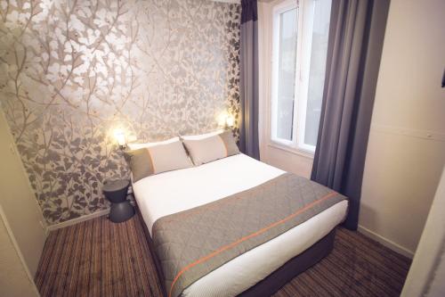 a bedroom with a bed in a room with a window at Timhotel Paris du Gare du Nord in Paris