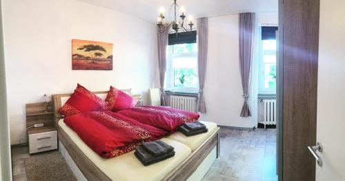 a bedroom with a bed with red pillows on it at Erboys Ferienwohnung in Goslar