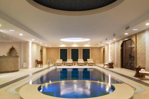 une piscine au milieu du hall de l'hôtel dans l'établissement Auberge du Jeu de Paume, à Chantilly