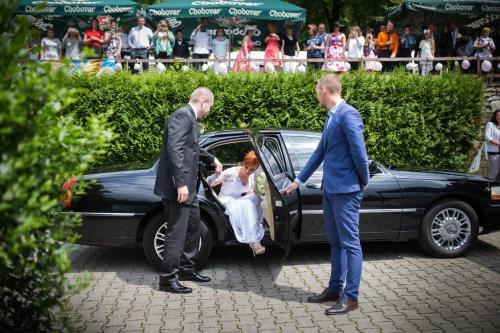 a bride getting out of a car with two men at Hospoda U Lípy in Ostrov