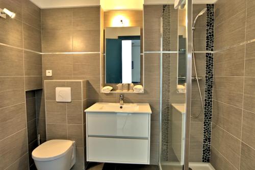 a bathroom with a toilet, sink, and shower at Hotel la Parata in Ajaccio