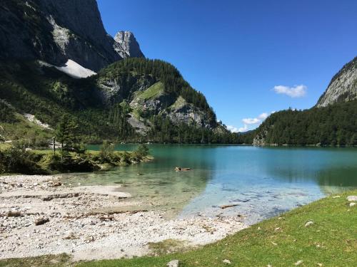 a mountain lake with people swimming in the water at Ferienwohnung Kogelblick Gosau in Gosau