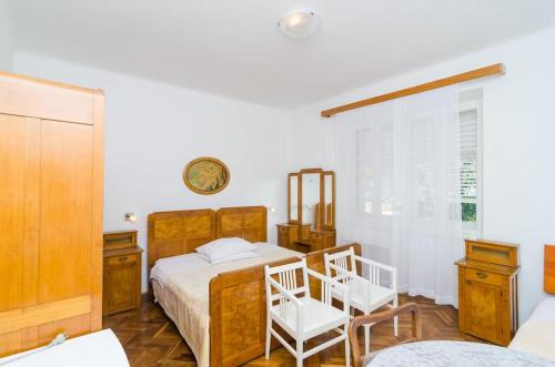 ドゥブロヴニクにあるRooms Ivo 1のベッドルーム1室(ベッド1台、椅子2脚付)