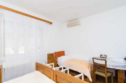 ドゥブロヴニクにあるRooms Ivo 1のベッド2台とテーブルと窓のある寝室