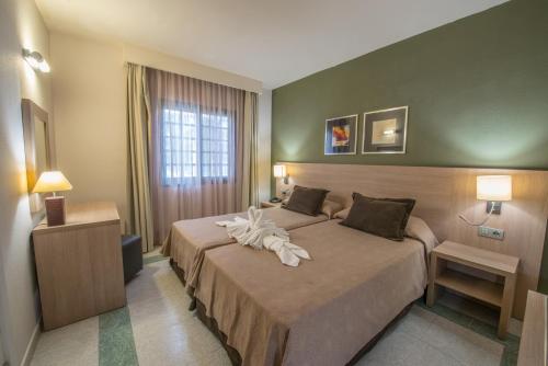 a hotel room with two beds with towels on them at Relaxia Lanzasur Club - Aqualava Water Park in Playa Blanca