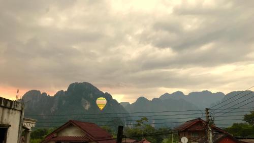 a view of a mountain with the sun in the distance at Nice view guesthouse in Vang Vieng