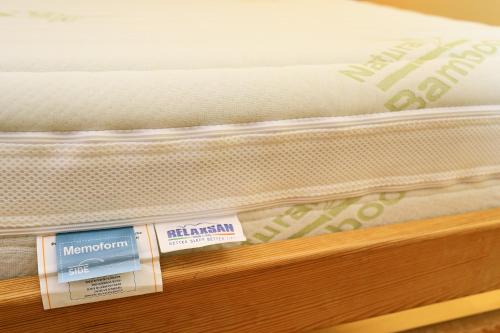 a mattress sitting on a wooden shelf with labels on it at Hotel Garni Myší Díra in Český Krumlov