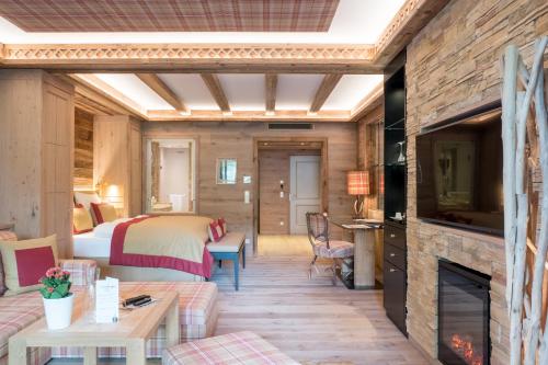 a hotel room with a bed and a fireplace at Alpin Resort Sacher in Seefeld in Tirol