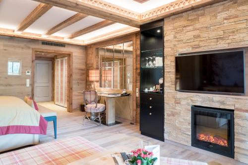 a living room with a fireplace and a tv at Alpin Resort Sacher in Seefeld in Tirol