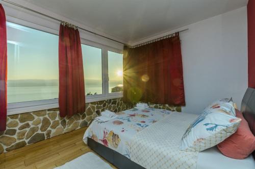 a bedroom with a bed and a large window at Apartments Bluesun in Omiš